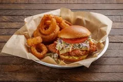 Catering 35 Fried Chicken Sandwich featuring crispy buttermilk chicken breast with Havarti cheese, honey mustard, coleslaw, tomato, and pickles on a brioche bun.