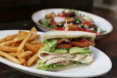 Home 105 Half sandwich with turkey, lettuce, tomato, and avocado, served with fries and a choice of fresh salad.