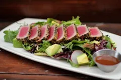 Catering 52 Seared Ahi Tuna Salad featuring rare seared yellowfin tuna over field greens with avocado, carrots, pickled cucumbers, and ponzu vinaigrette.
