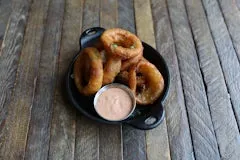 Happy Hour 21 Side Onion Rings featuring crispy golden-brown onion rings served with a side of house dipping sauce.