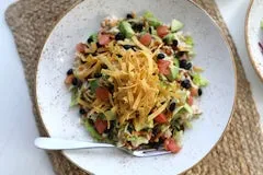 Catering 50 Tex-Mex Salad with shredded chicken breast, black beans, avocado, tomatoes, BBQ sauce, tortilla strips, and chipotle ranch dressing.